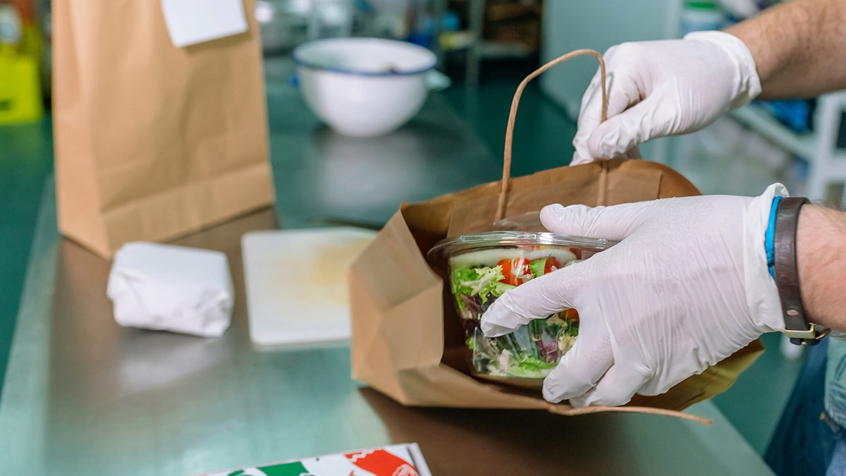 Unrecognizable cook packing a takeaway order