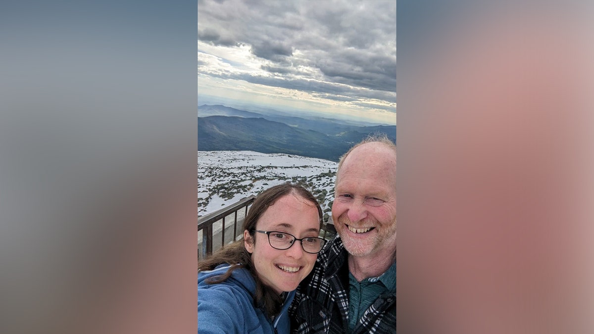 Tim and Esther Keiderling selfie with mountain behind them