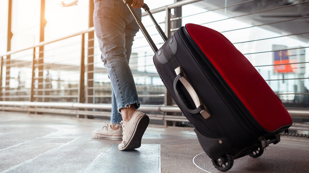 Woman walking with suitcase at airport