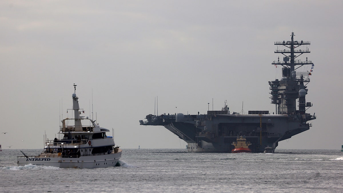 USS Nimitz next to a fishing boat in San Diego