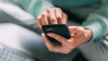 A person receiving a scam text message on their phone