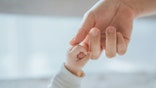 Close-up little hand of child baby holding hand of mother