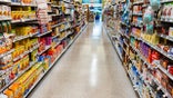 This aisle in a supermarket is fully stocked with non perishable food and dry goods.