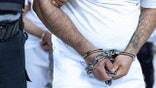 Tren de Aragua gang member in custody, handcuffed