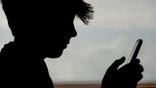 PENZANCE, UNITED KINGDOM - MAY 26: In this photo illustration, a 13-year-old boy looks at an iPhone screen on May 26, 2025 in Penzance, England. The amount of time children spend on screens each day rocketed during the Covid pandemic by more than 50 per cent, the equivalent of an extra hour and twenty minutes. Researchers say that unmoderated screen time can have long-lasting effects on a child's mental and physical health. Recently TikTok announced that every account belonging to a user below age 18 have a 60-minute daily screen time limit automatically set. (Photo by Matt Cardy/Getty Images)