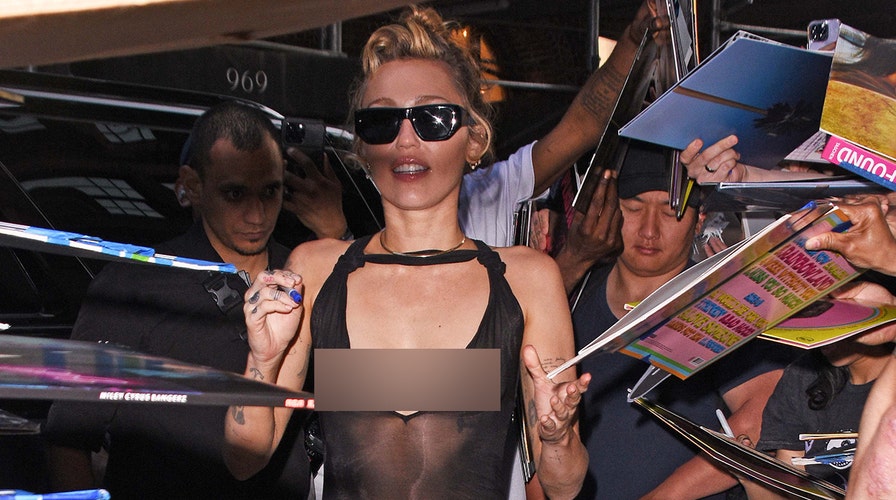 Miley Cyrus walks red carpet at Grammys in gold