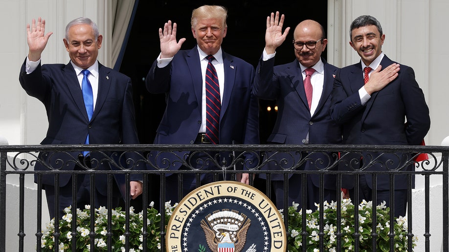 Leaders wave on a balcony