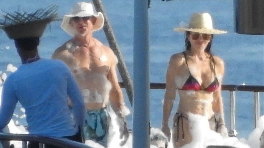 Jeff Bezos and Lauren Sanchez standing next to each other on a boat during a foam party.