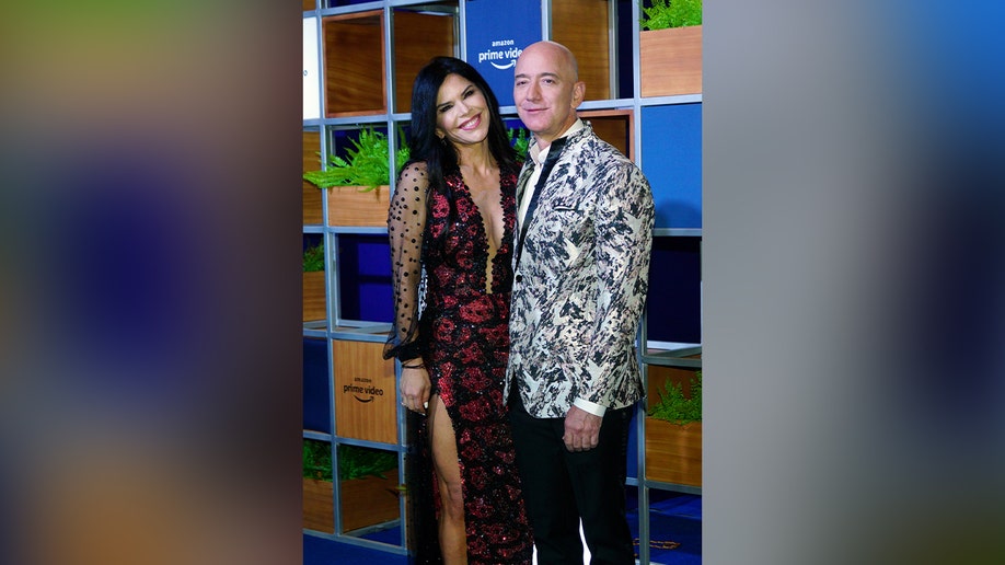 Jeff Bezos and Lauren Sanchez posing together on the red carpet for Amazon.