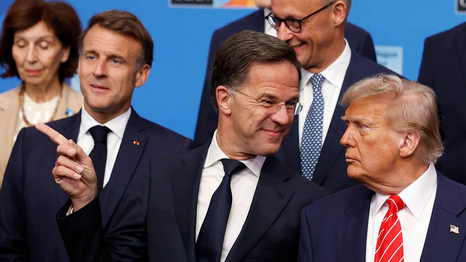 Trump and NATO Secretary General Mark Rutte converse during a group photo.