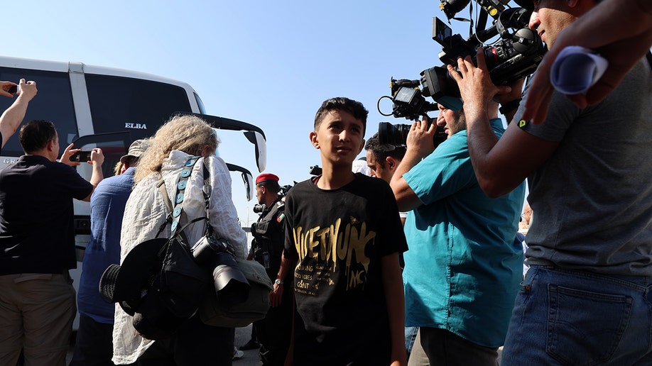 A Palestinian boy looks on at cameras before being evacuated from the Gaza Strip through Jordan's medical corridor.