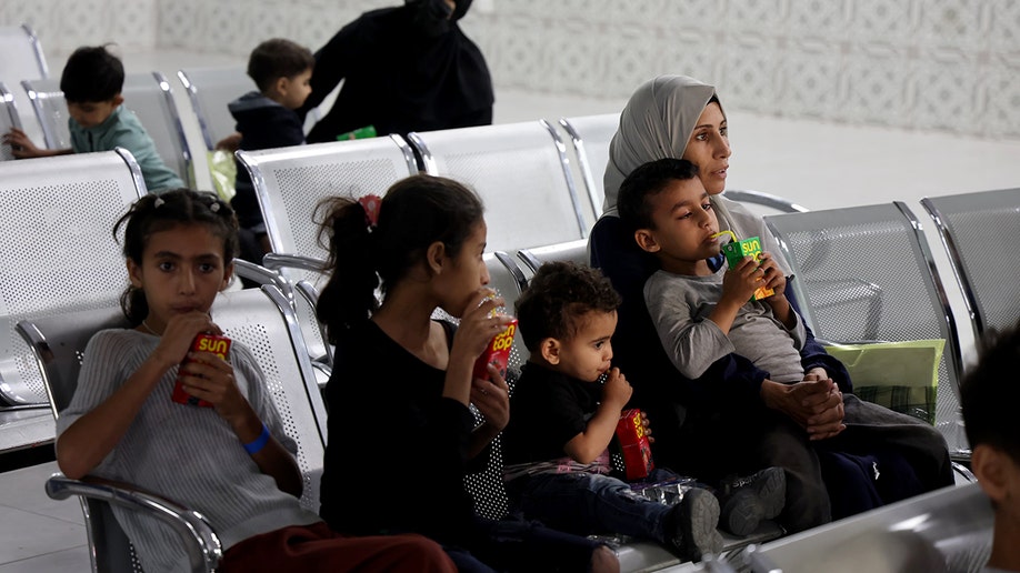 Palestinian children sip juice boxes ahead of their evacuation from the Gaza Strip via the Jordan Medical Corridor.