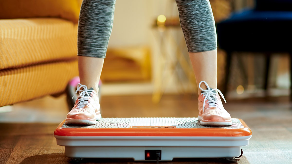 Woman using a vibration plate at home