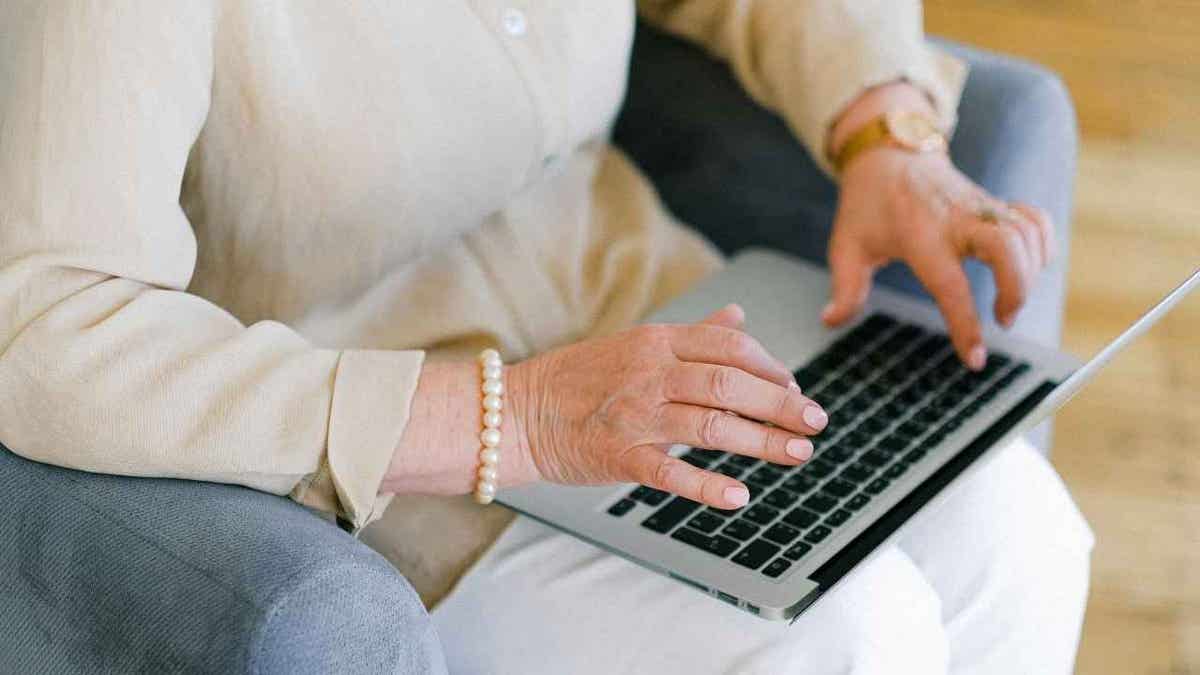 Woman typing on a laptop.