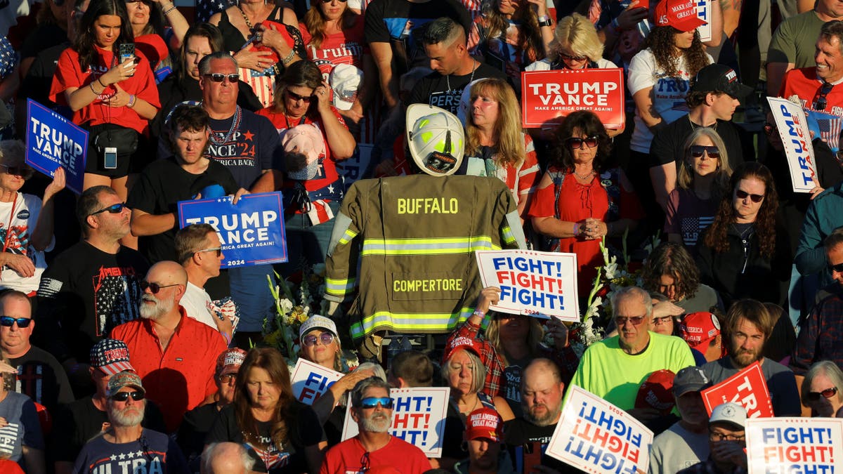 Corey Comperatore’s turnout coat is displayed in the crowd during a moment of silence at a Trump rally in Butler, Pa., honoring the slain volunteer fire chief.