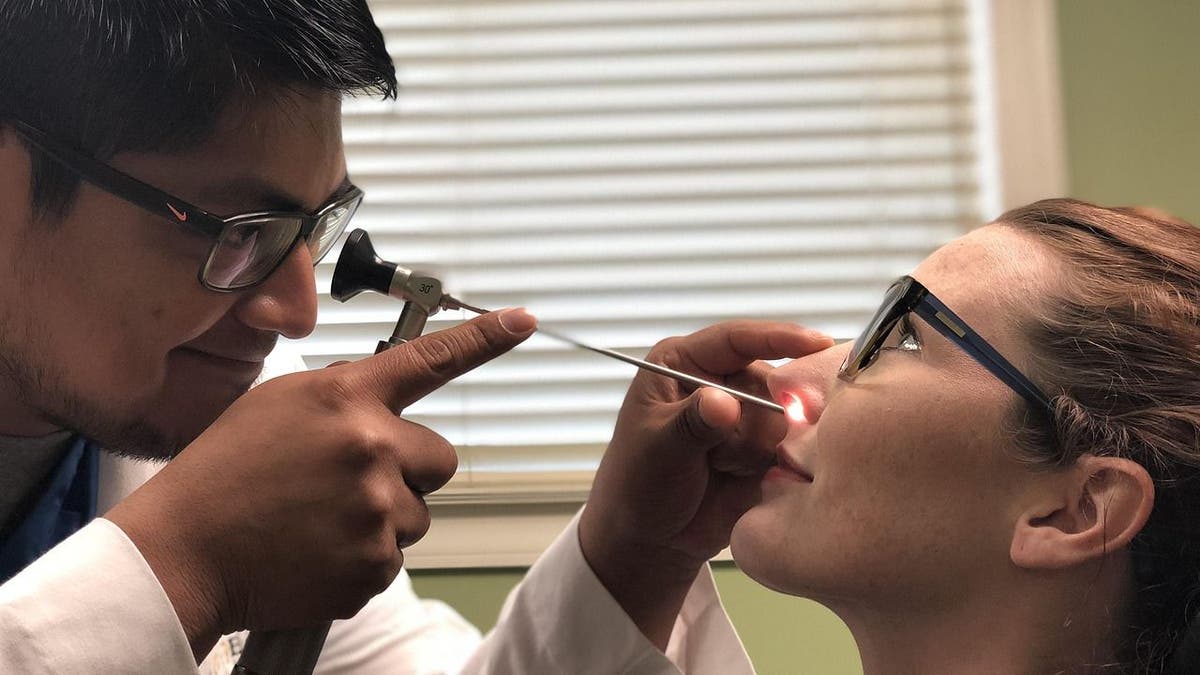 A doctor examining a woman with a sinus infection.
