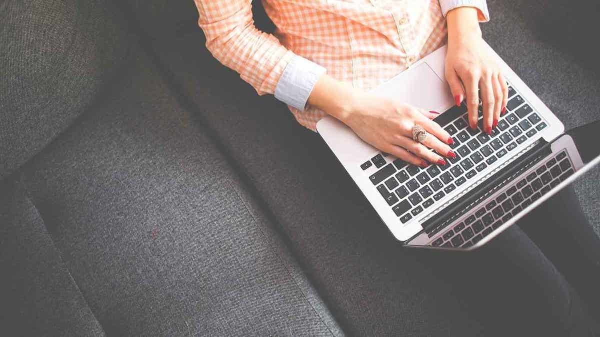 Woman typing on a laptop.