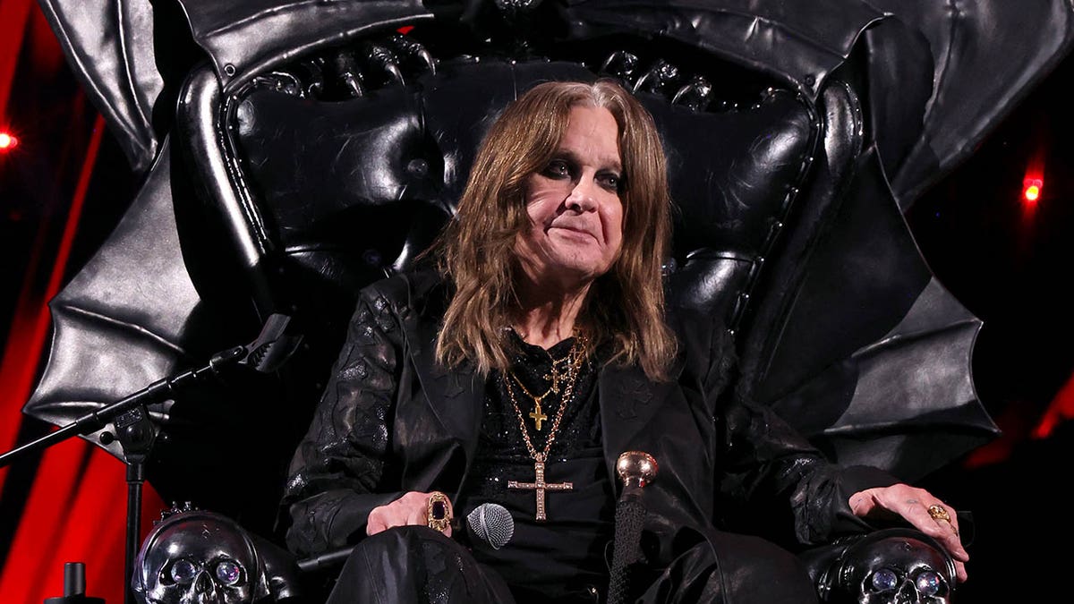 ozzy osbourne sitting in a black throne at his rock and roll hall of fame induction