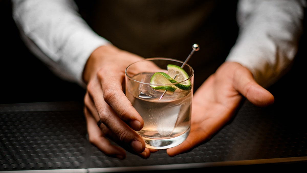 Hand holding tequila in glass