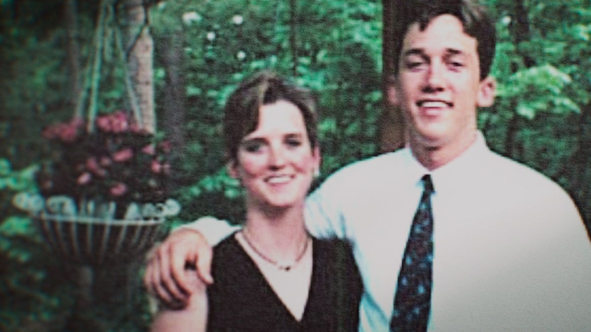 Amy Bradley wearing a black strappy dress being embraced by her brother.