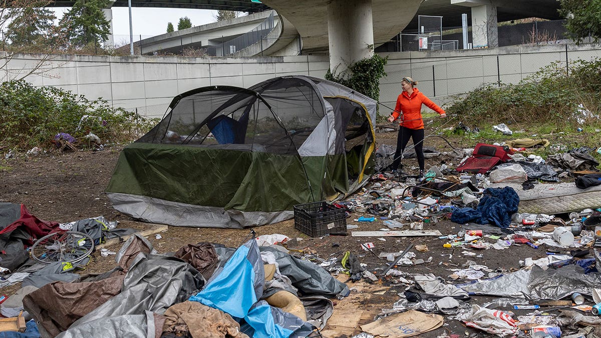 Andrea Suarez dismantles a tent surrounded by garbage at a homeless encampment on March 13, 2022, in Seattle. (John Moore/Getty Images)