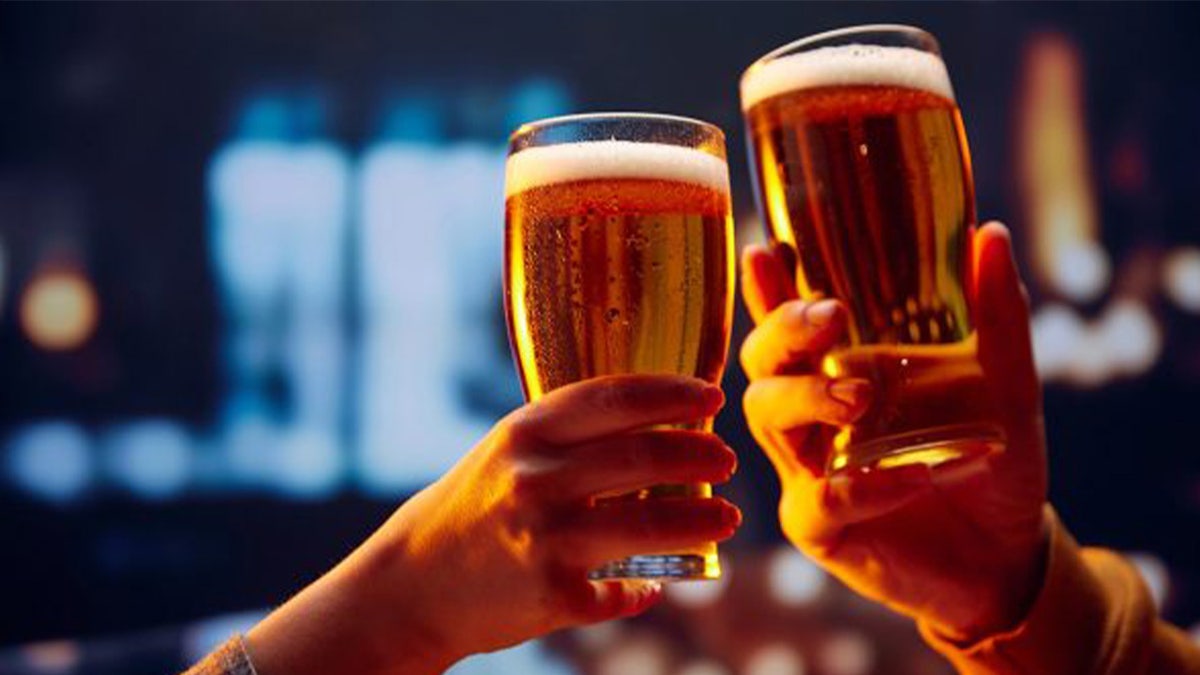 Beer glasses being held together in a toast