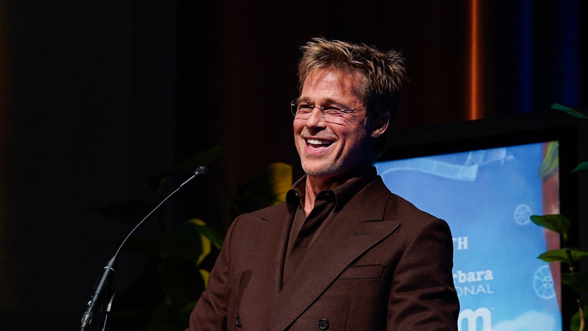 Brad Pitt smiles at podium