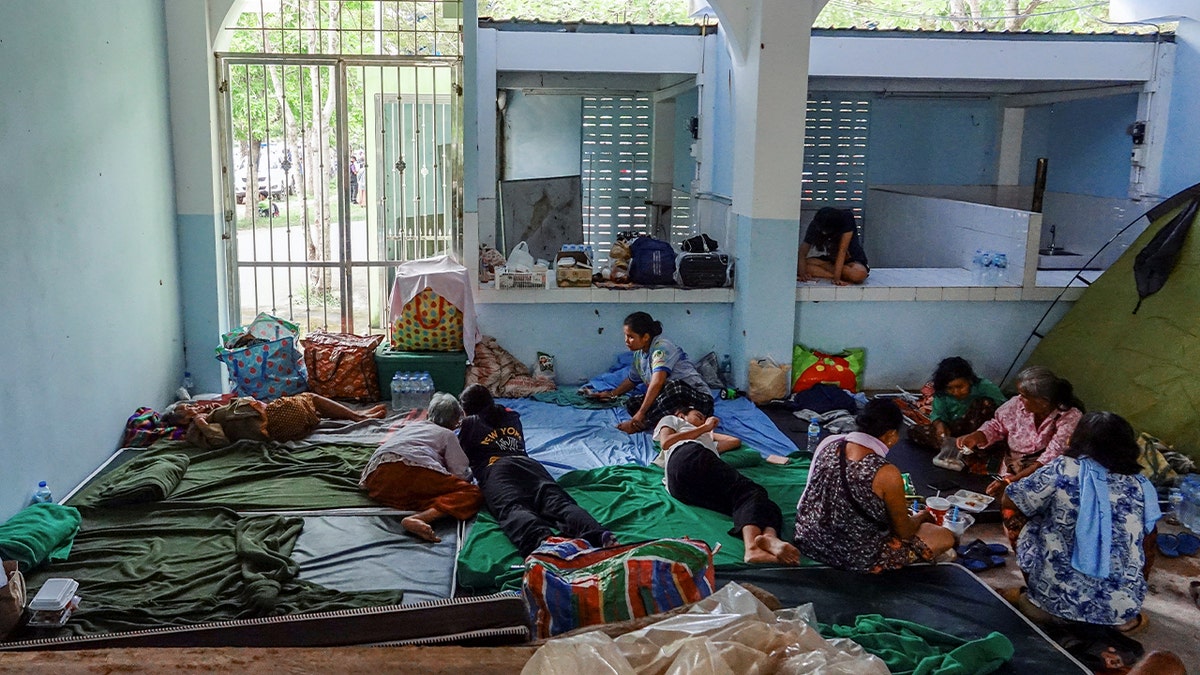 People rest at a shelter in Thailand as the country clashes with neighboring Cambodia