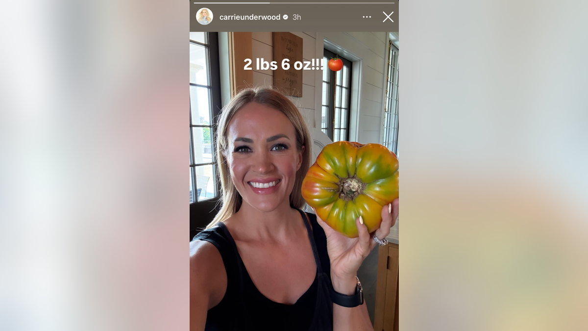 Carrie underwood holding a large tomato