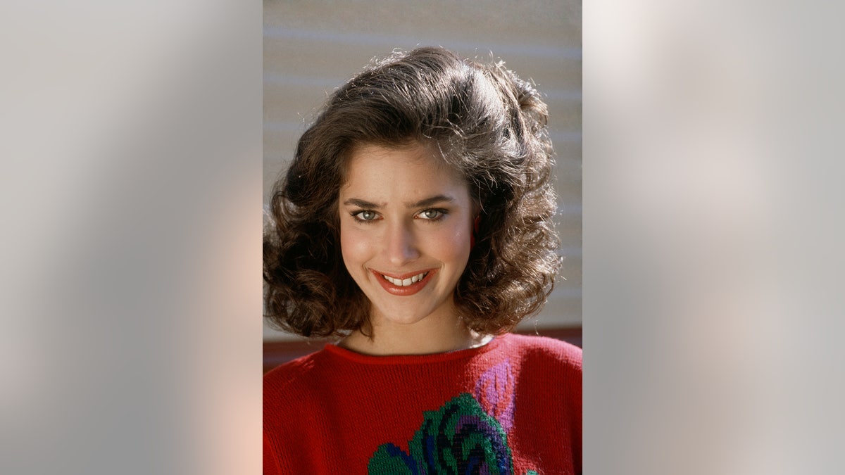 Claudia Wells wearing a red sweater.