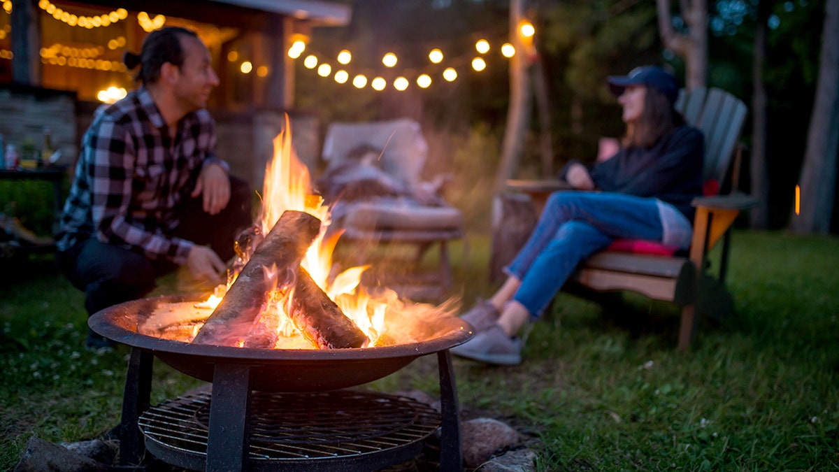 family warming near backyard campfire