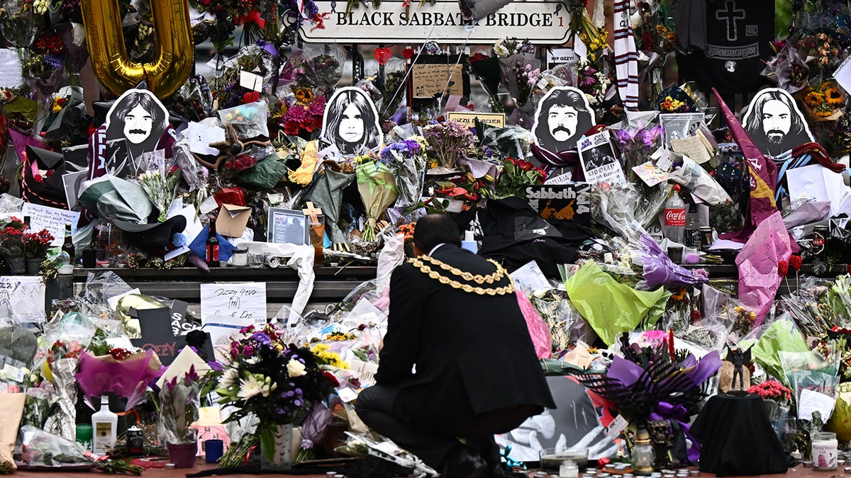 Councillor Zafar Iqbal observes the tributes to Ozzy Osbourne before his funeral cortége