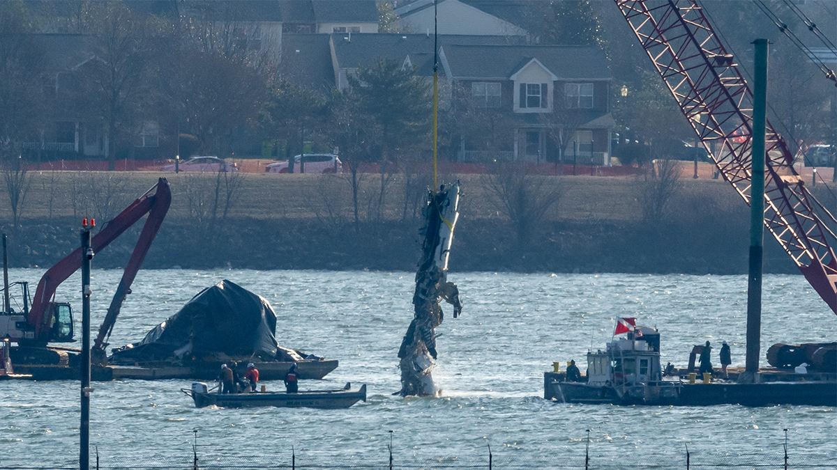 A piece of wreckage is lifted from the water
