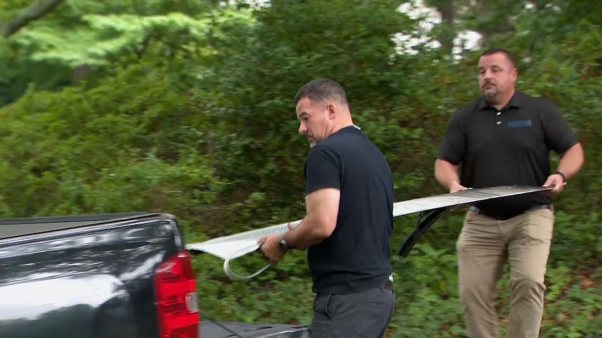 Workers remove wing flaps that fell from the Boeing 737-900 from a North Carolina driveway.