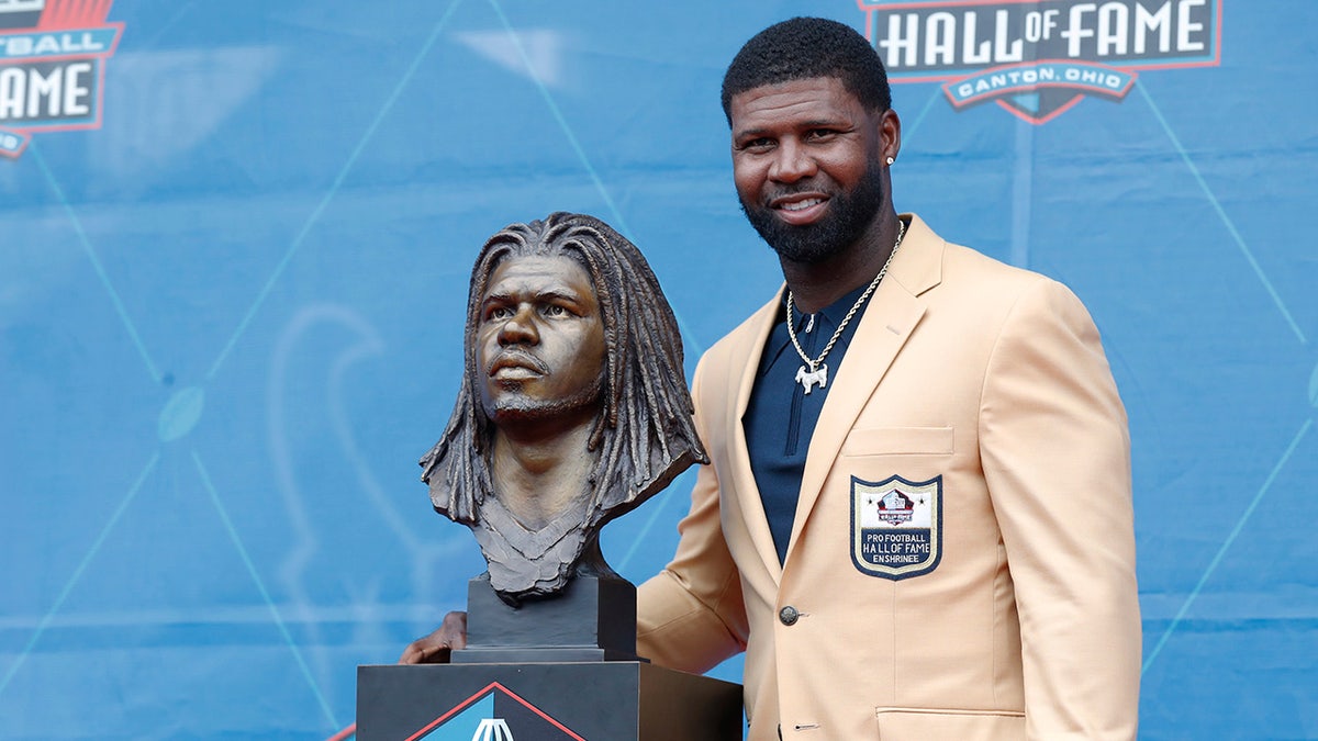 Devin Hester poses next to Hall of Fame bust