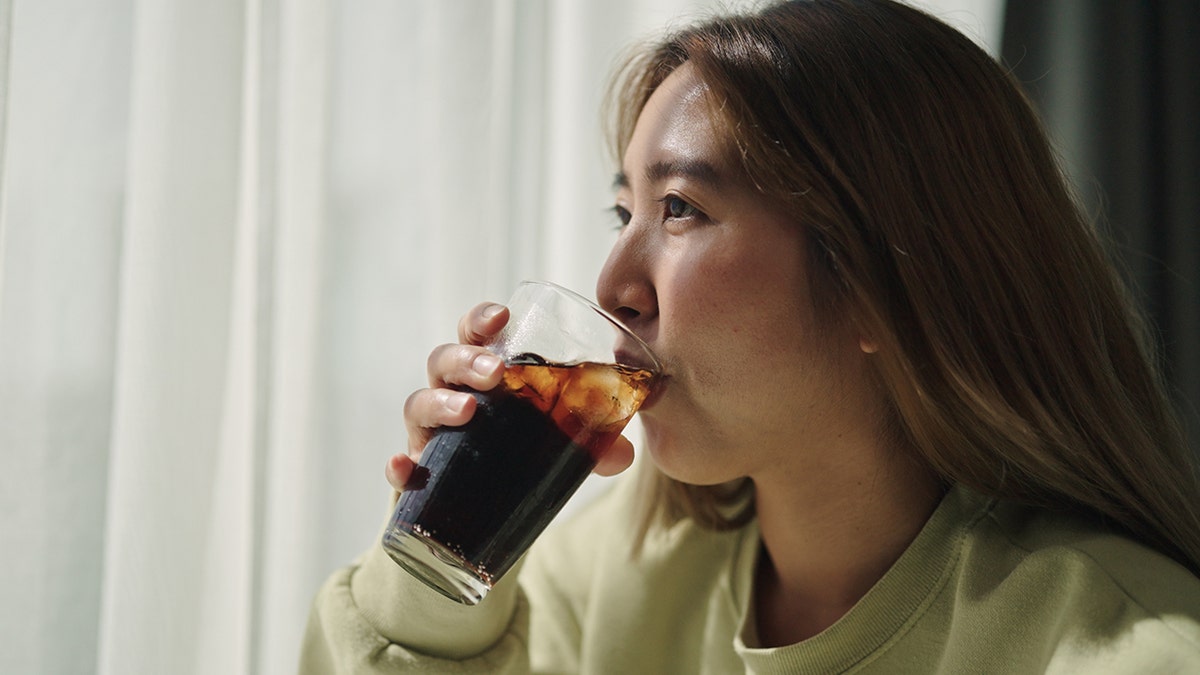 Young woman sipping soda