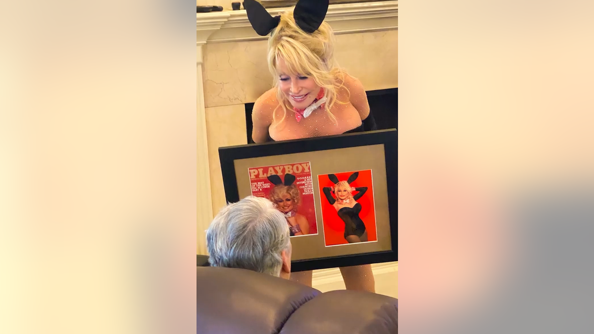Dolly Parton, kas 2021. gadā pozē melnā Playboy Bunny kostīmā un nodeva ierāmētu fotoattēlu vīram Carl Dean