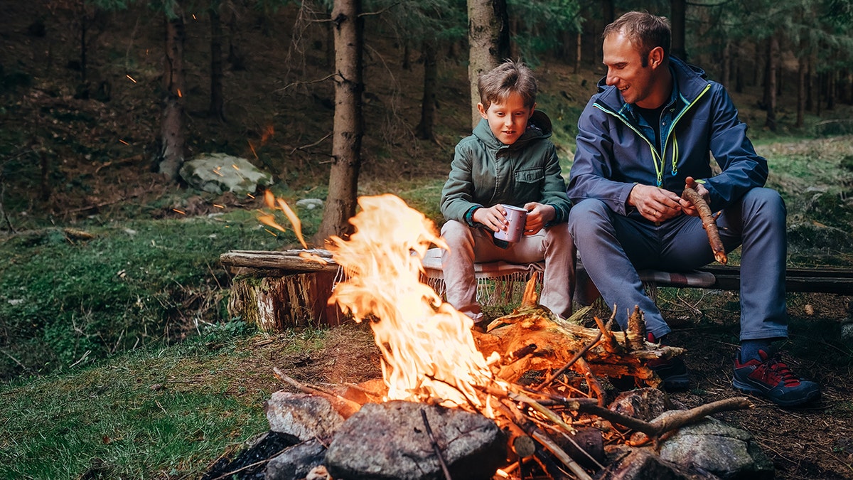Father and son sitting by the bonfire