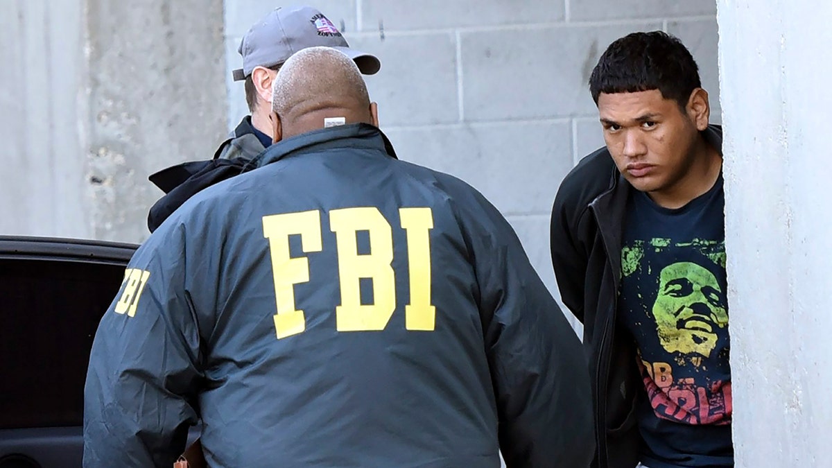 FBI agents escort Saenz in handcuffs