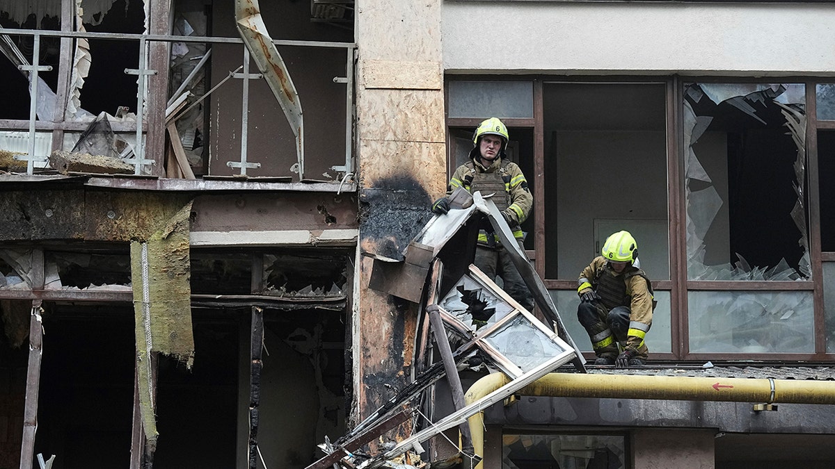 The firefighters work in a building destroyed in Ukraine