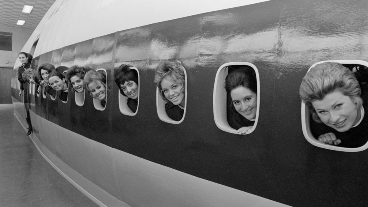 30th March 1971: BOAC stewardesses peering through the port holes of the mock-up Jumbo Jet 747 at London's Heathrow Airport during training for the introduction of transatlantic Jumbo flights. (Photo by Dennis Oulds/Central Press/Getty Images)