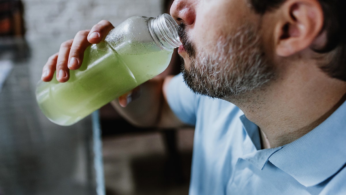 Man drinking cloudy green drink