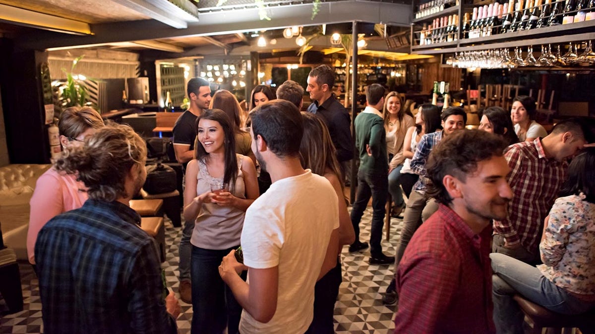 Group of people having drinks at a bar and looking very happy