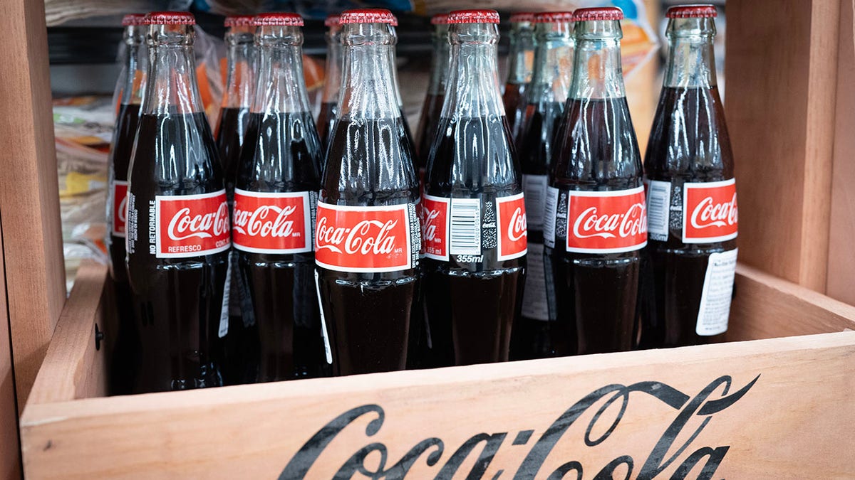 Glass COke bottles seen in wooden crate