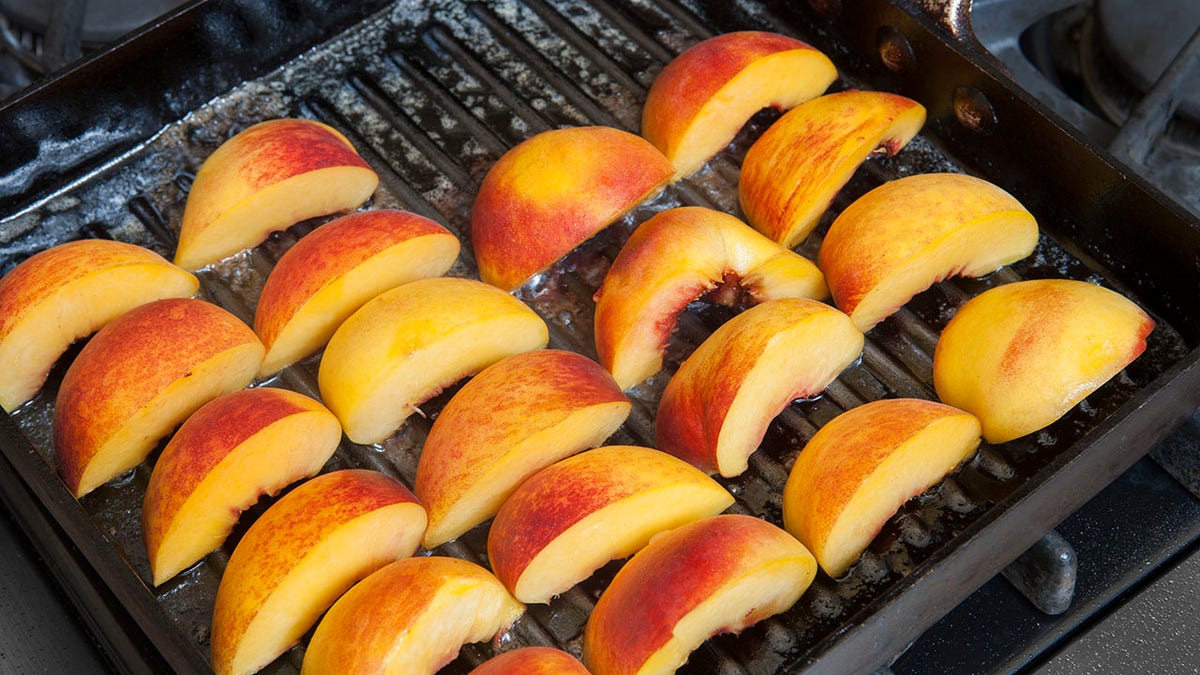 Peaches seen sliced and on a grill