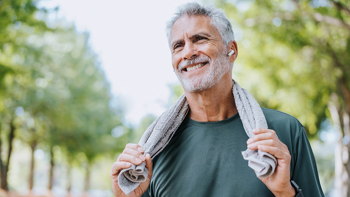 Senior man holding towel around neck