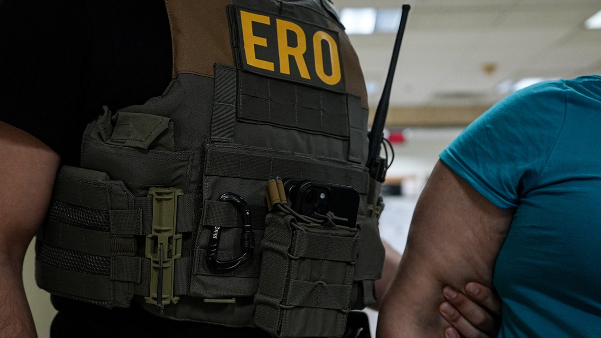 Agent Rue holding an illegal arm of immigrant