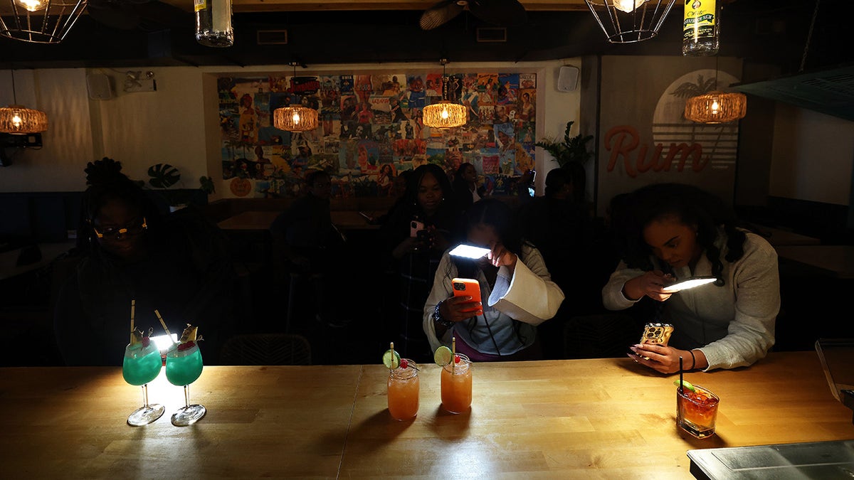 Three influencers seen at bar all photographing their cocktails