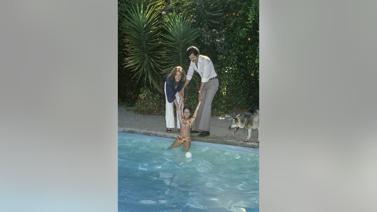 Jennifer Aniston spending time with her parents at a pool in 1975