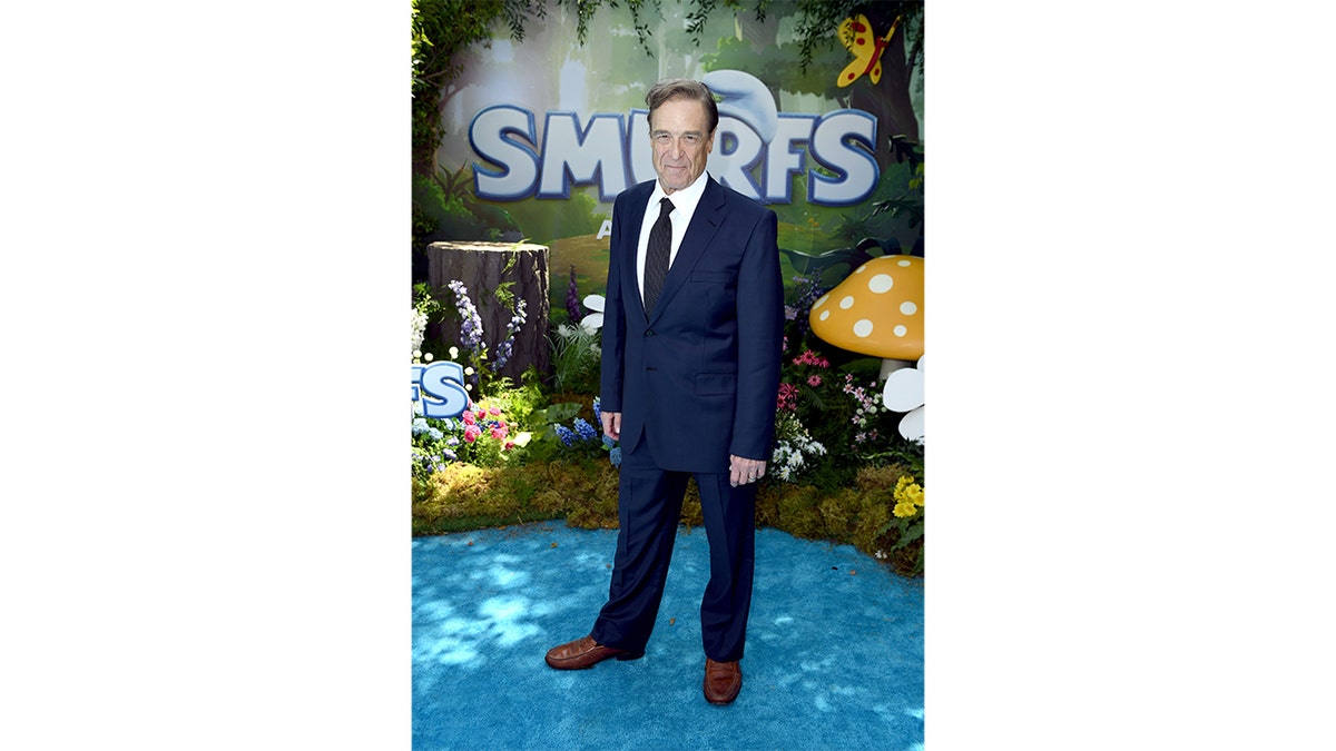 John Goodman wears a suit at the Smurfs premiere